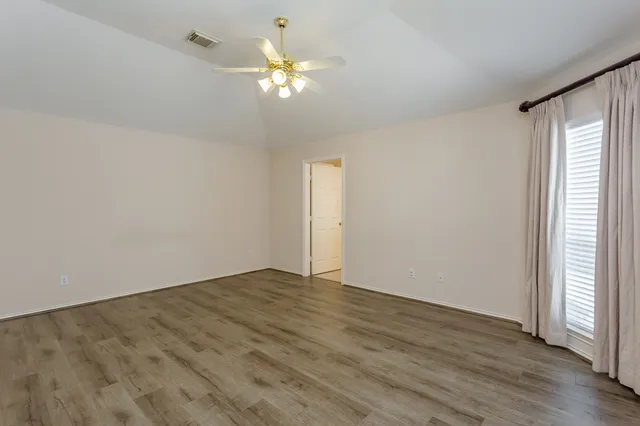 a view of an empty room with wooden floor