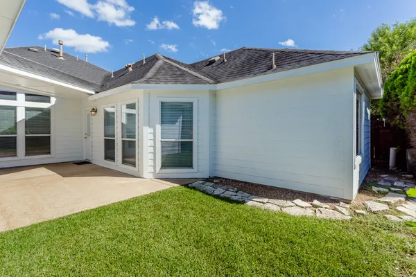 a view of a house with backyard and a tree