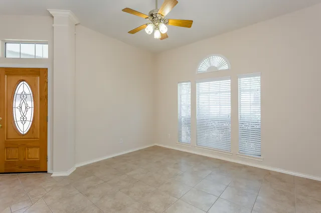 an empty room with windows closet and fan