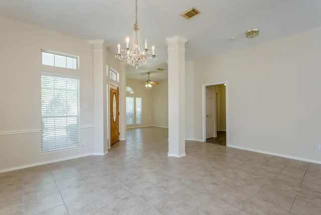 a view of a chandelier in big room and windows