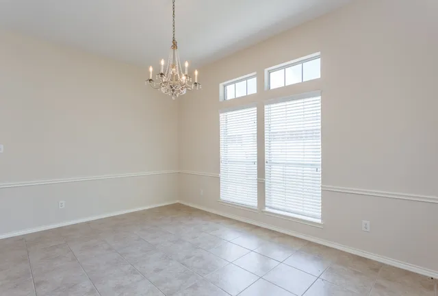 a view of an empty room with chandelier