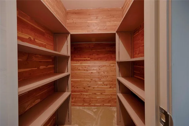 a view of an empty room with wooden floor and staircase