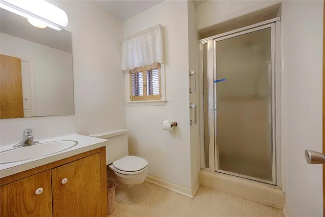 a bathroom with a toilet a sink and shower