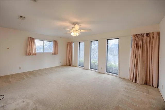an empty room with windows and closet area