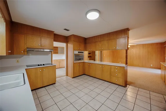 a kitchen with granite countertop a refrigerator and a stove top oven