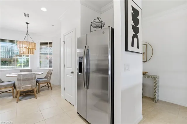 a kitchen with refrigerator a table and chairs