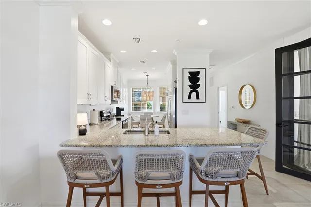 a dining hall with stainless steel appliances granite countertop a dining table and chairs