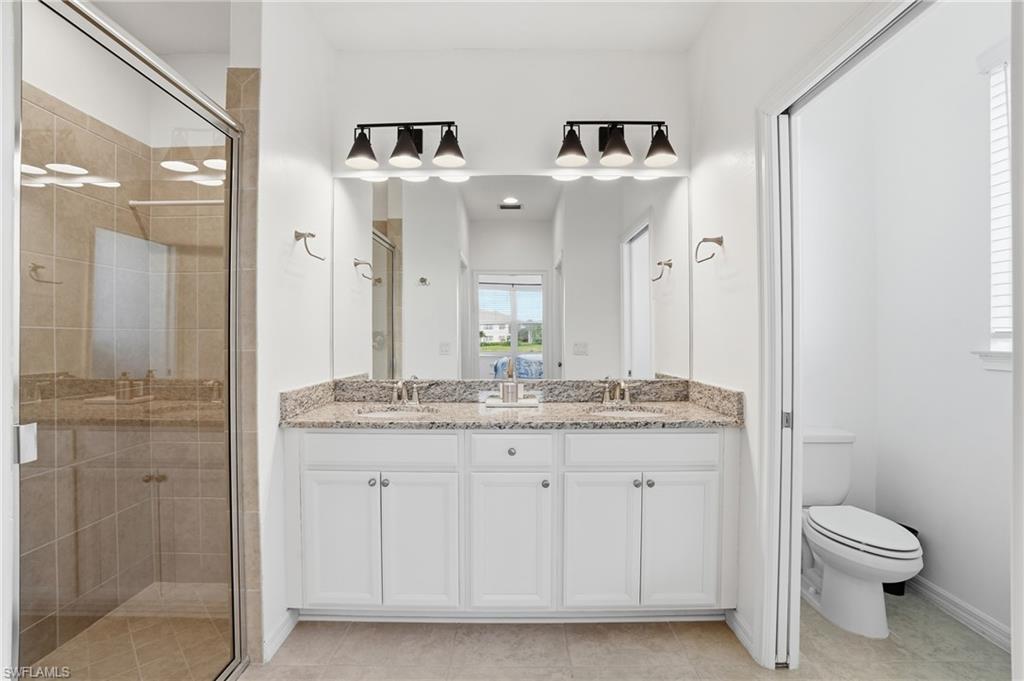 9374 Pocida Court, Unit 101 Naples, FL 34119 - Photo 20 of 32 a bathroom with a granite countertop sink a toilet and shower
