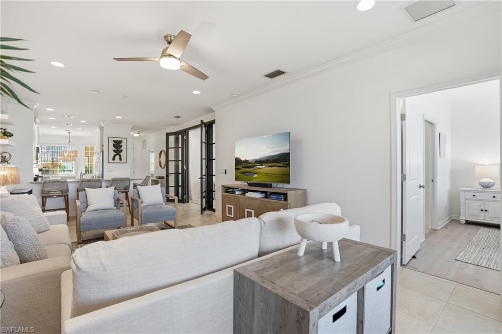 9374 Pocida Court, Unit 101 Naples, FL 34119 - Photo 2 of 32 a living room with furniture and a flat screen tv