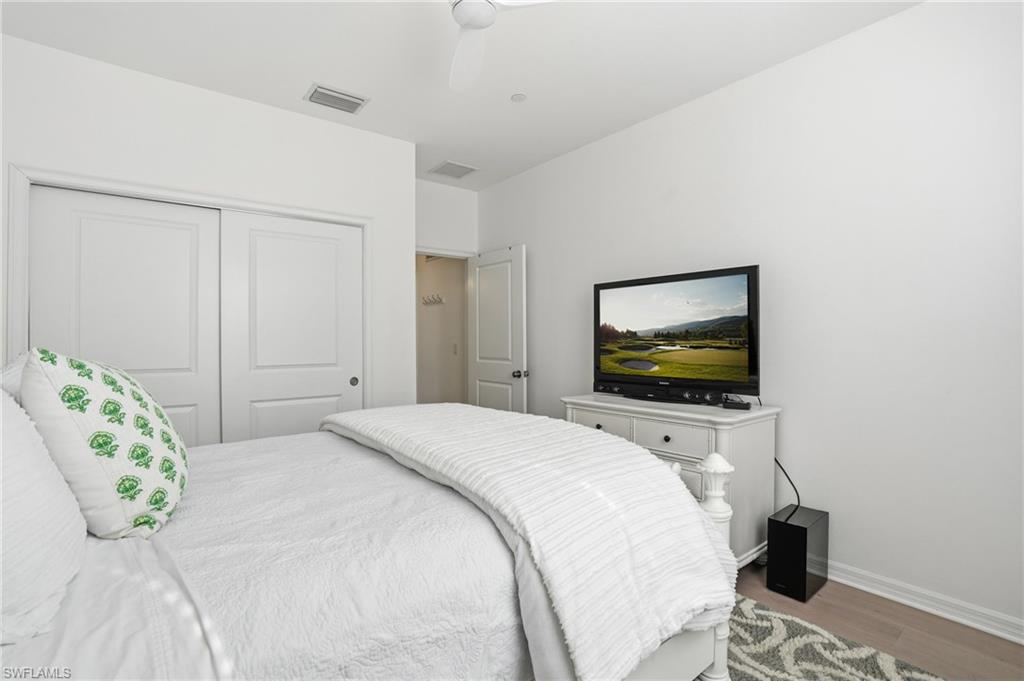 9374 Pocida Court, Unit 101 Naples, FL 34119 - Photo 21 of 32 a bedroom with a bed and a flat screen tv