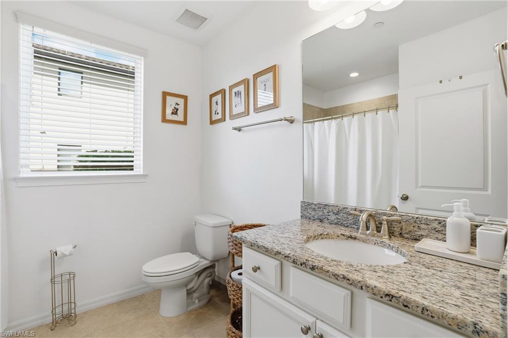 9374 Pocida Court, Unit 101 Naples, FL 34119 - Photo 22 of 32 a bathroom with a granite countertop sink and a toilet