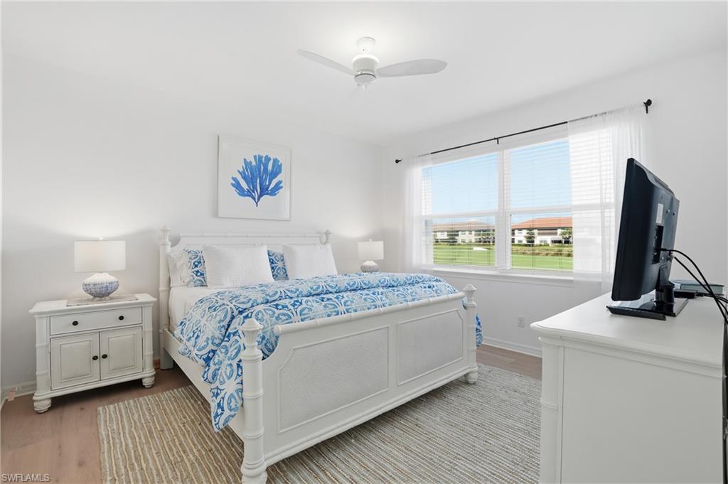 9374 Pocida Court, Unit 101 Naples, FL 34119 - Photo 5 of 32 a bedroom with a bed and a flat screen tv