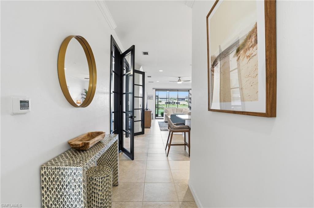 9374 Pocida Court, Unit 101 Naples, FL 34119 - Photo 7 of 32 a view of entryway and hall with wooden floor