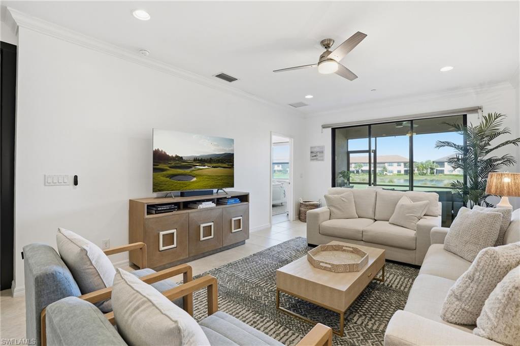 9374 Pocida Court, Unit 101 Naples, FL 34119 - Photo 9 of 32 a living room with furniture and a flat screen tv