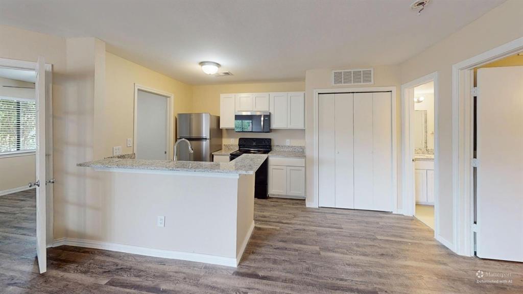 9837 Walnut Street, Unit 103 Dallas, TX 75243 - Photo 2 of 10 a kitchen with a refrigerator and a stove