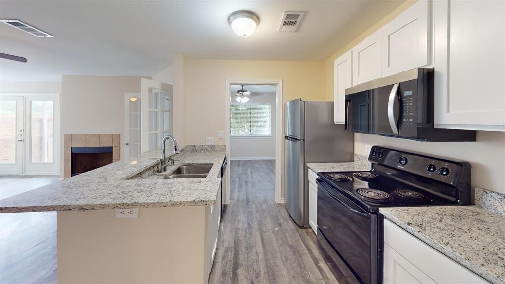 9837 Walnut Street, Unit 103 Dallas, TX 75243 - Photo 3 of 10 a kitchen with stainless steel appliances granite countertop a stove refrigerator sink and microwave