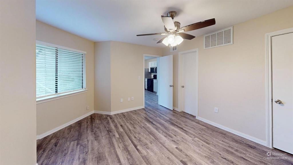 9837 Walnut Street, Unit 103 Dallas, TX 75243 - Photo 6 of 10 a view of an empty room with wooden floor and a window
