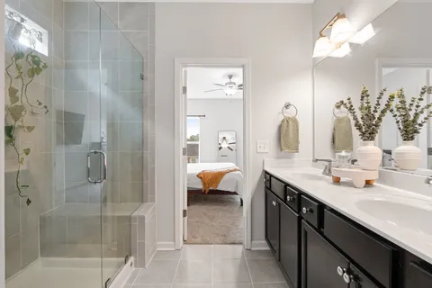 a en suite bathroom with a double vanity sink mirror and shower