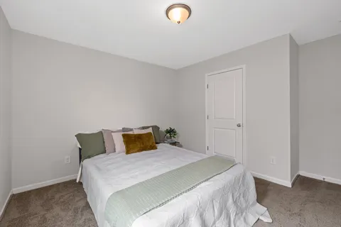 a bedroom with a bed and white wall