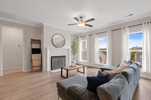 a living room with furniture a fireplace and a large window
