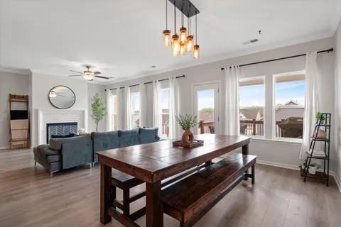 a large living room with a table chairs and a large window