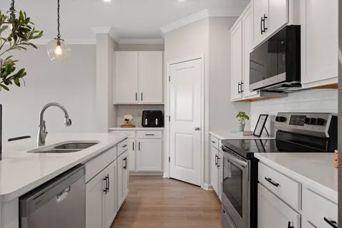 a kitchen with stainless steel appliances granite countertop a sink a stove a microwave and a refrigerator