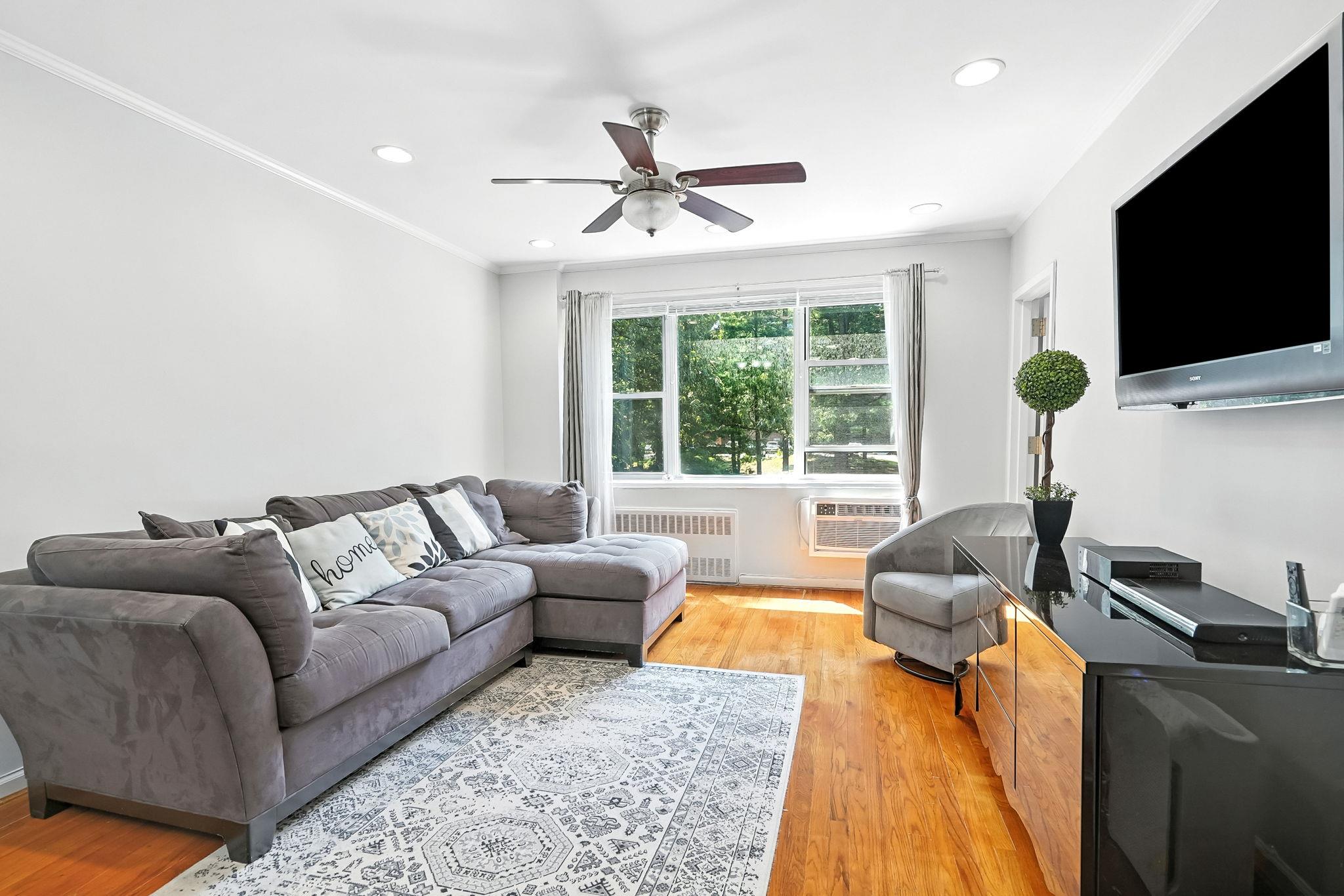 a living room with furniture tv and a flat screen tv