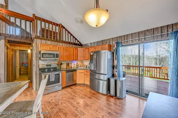 a kitchen with stainless steel appliances granite countertop a refrigerator a stove and a wooden floors