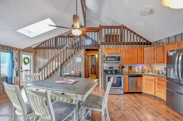 a open kitchen with stainless steel appliances granite countertop a stove refrigerator dining table and chairs