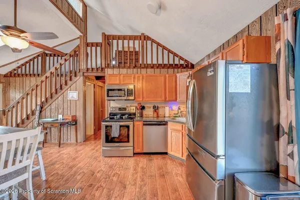 a kitchen with stainless steel appliances a refrigerator and a wooden floor