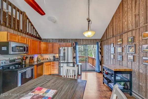 a kitchen that has a lot of cabinets stainless steel appliances and wooden floor