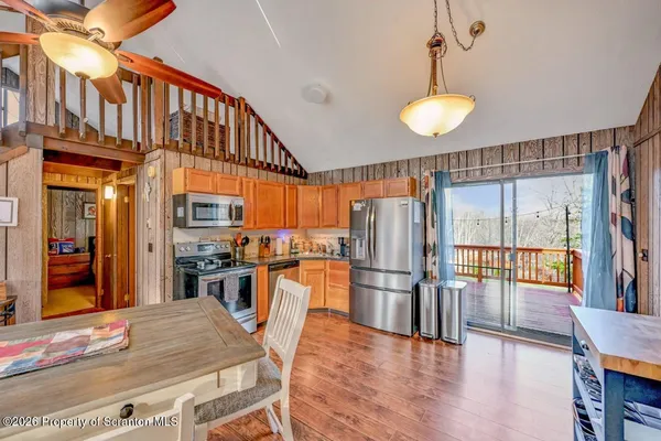a kitchen with stainless steel appliances granite countertop a refrigerator a stove and a wooden floors