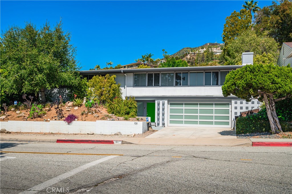 105 West Kenneth Road Glendale, CA 91202 - Photo 3 of 48 a front view of a house with a yard and potted plants