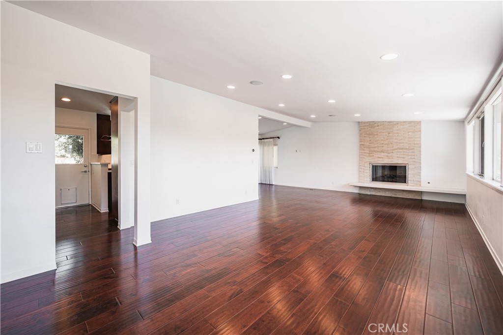 105 West Kenneth Road Glendale, CA 91202 - Photo 9 of 48 an empty room with wooden floor fireplace and windows