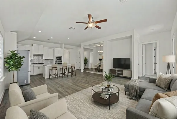 a living room with furniture kitchen view and a potted plant