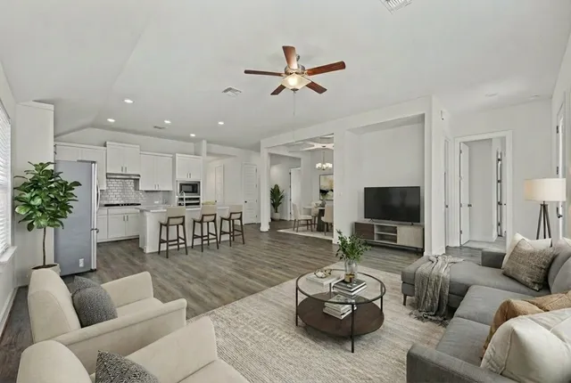 a living room with furniture kitchen view and a potted plant