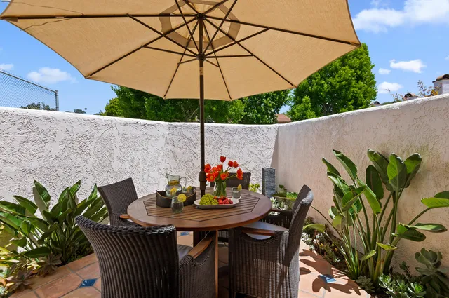 a outdoor dining space with furniture and umbrella