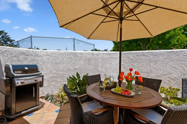 a outdoor dining space with furniture and umbrella