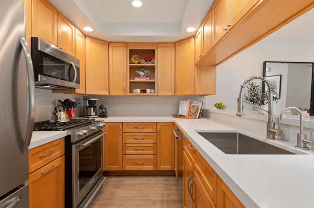 a kitchen with stainless steel appliances granite countertop a sink stove and microwave