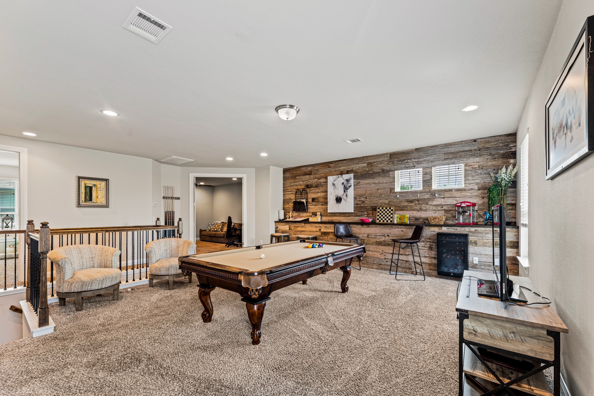 108 Redtail Lane Leander, TX 78641 - Photo 20 of 39 A rustic accent wall and full wall to wall bar complements this versatile entertainment space, complete with a pool table, bar fridge, and in-floor outlets
