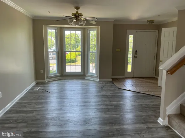 a hallway with wooden floor a fireplace and entryway