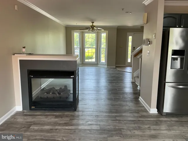 a view of a livingroom with a fireplace a chandelier and wooden floor