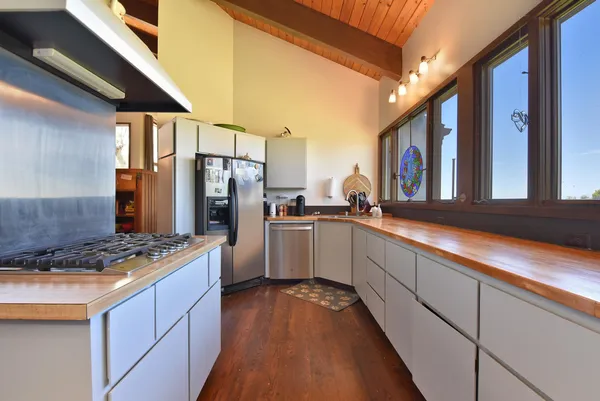 a kitchen with stainless steel appliances granite countertop a stove a sink and a refrigerator