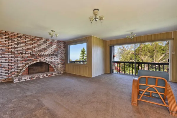 a view of empty room with fireplace and fan