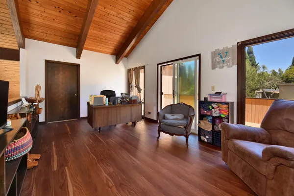 a view of balcony and deck with wooden floor and outdoor seating