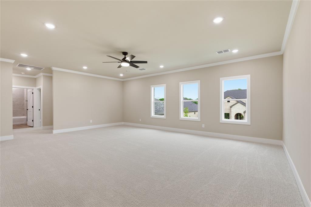 702 Anne Road Van Alstyne, TX 75495 - Photo 18 of 27 Spacious carpeted room featuring a ceiling fan, recessed lighting, crown molding, and three large windows