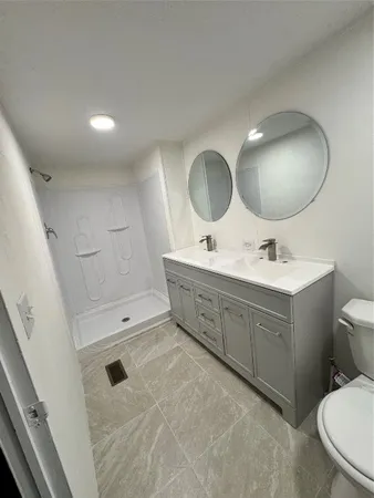 a bathroom with a double vanity sink mirror and toilet