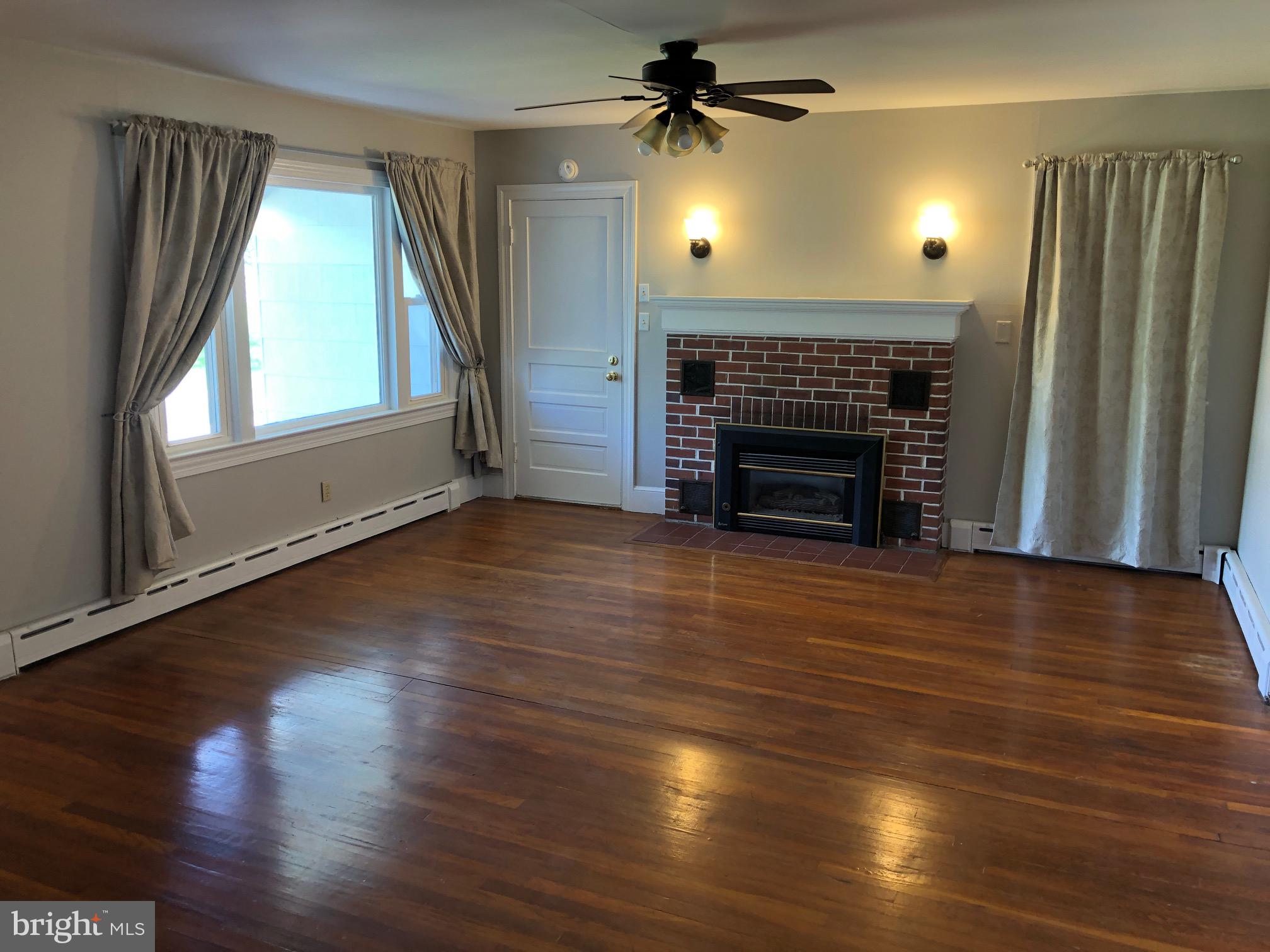 20618 Ridge Road Colonial Beach, VA 22443 - Photo 4 of 25 an empty room with wooden floor fireplace and window
