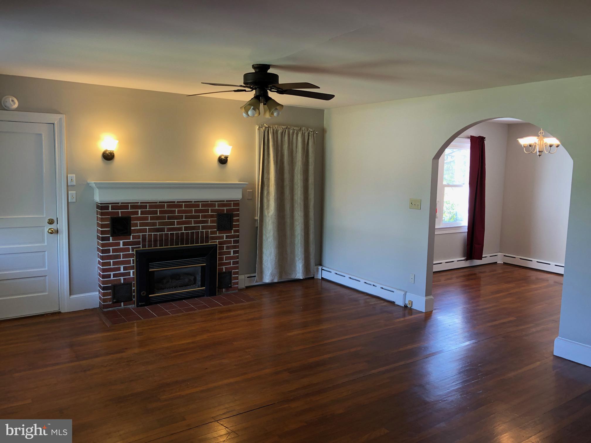 20618 Ridge Road Colonial Beach, VA 22443 - Photo 5 of 25 a view of an empty room with wooden floor fireplace and a window