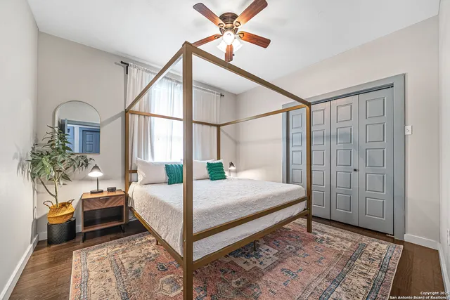 a bedroom with a bed a table and potted plant